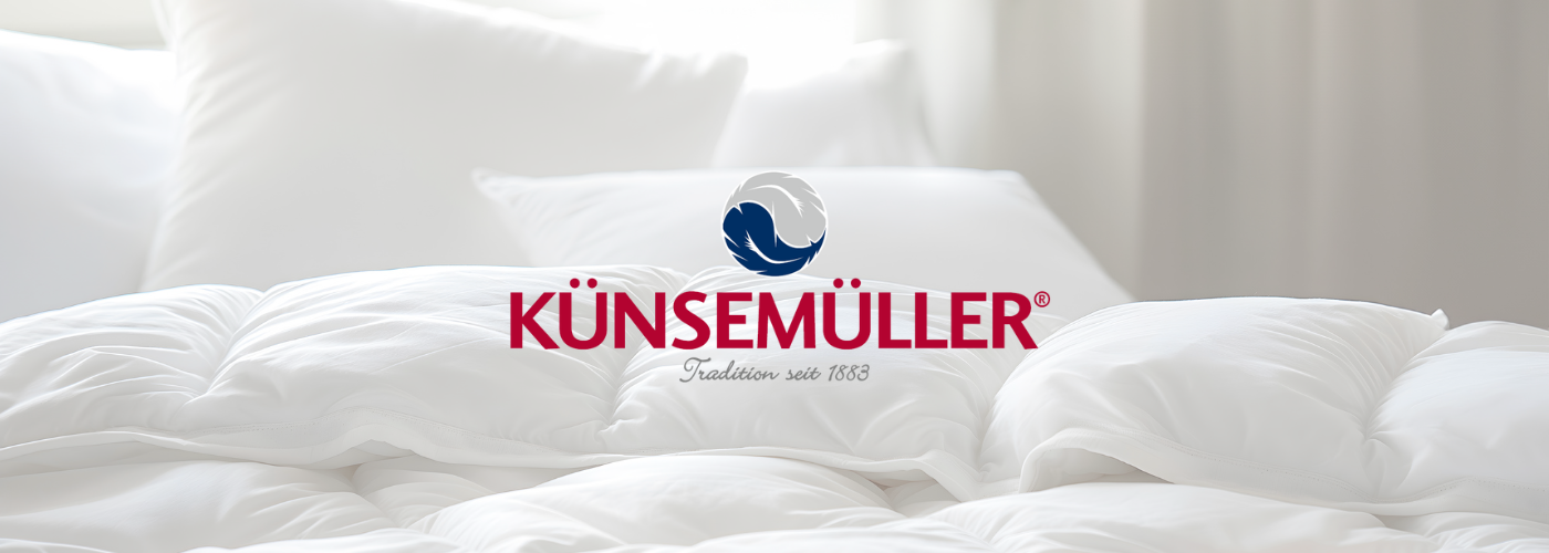 KÜNSEMÜLLER Logo. Im Hintergrund eine weiße Bettdecke und ein Kopfkissen.