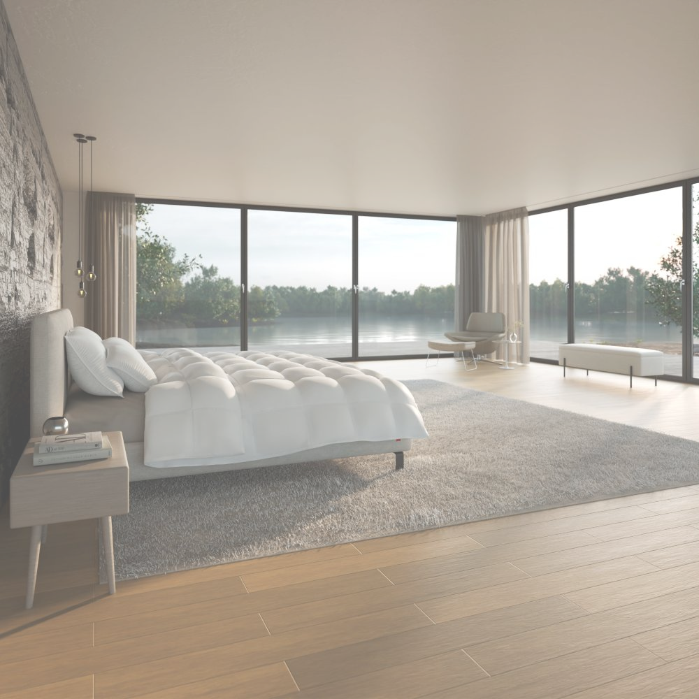 Schlafzimmer mit einer großen Fensterfront und einem Bett.